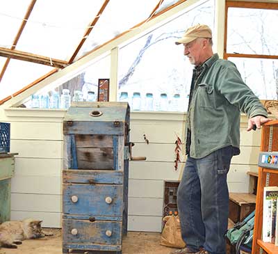 Albie Barden admiring a Benjamin & Co. corn sheller made in Winthrop, Maine, in the 1800s