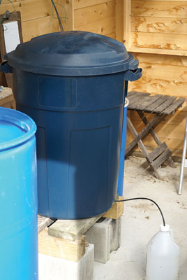 A 32-gallon bokashi container in a greenhouse