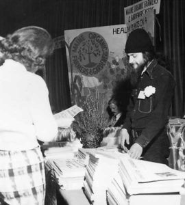 Tim Nason at the 1975 Trades Show surrounded by The MOF&G; Eliot Coleman is seated in the background.