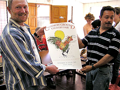 Paul Volckhausen presents a Common Ground Fair poster to Ernesto Morales of CORDES/CCR. English photo.