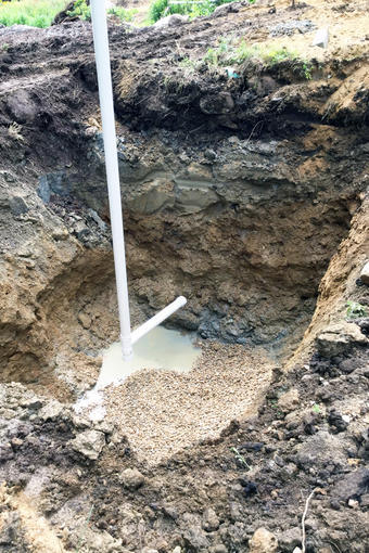 Casing and collector being lowered into well excavation