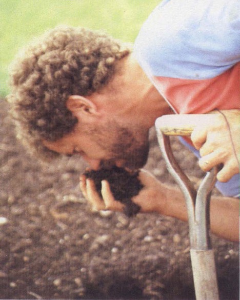 Farmer smelling soil to determine soil health