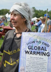 Woman holding a "How to End Global Warming" sign