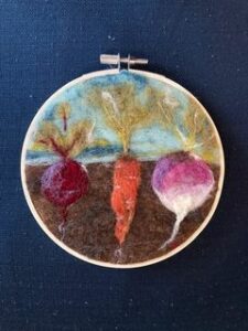 a felted radish, carrot, and turnip in an embroidery hoop.