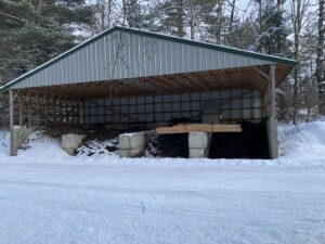 building with three sides and roof which is divided into stalls for compost