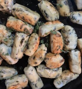 Dandelion gnocchi crisping in black cast iron skillet