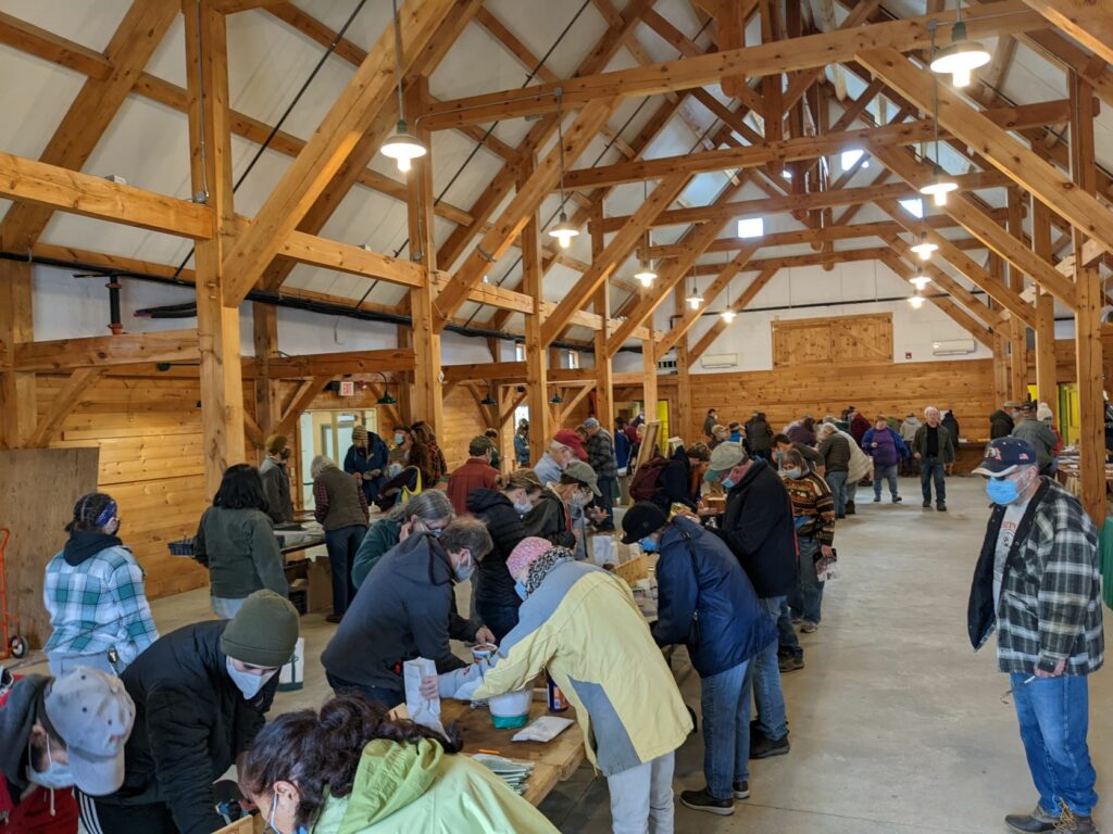 Participants standing around tables at a seed swap event.