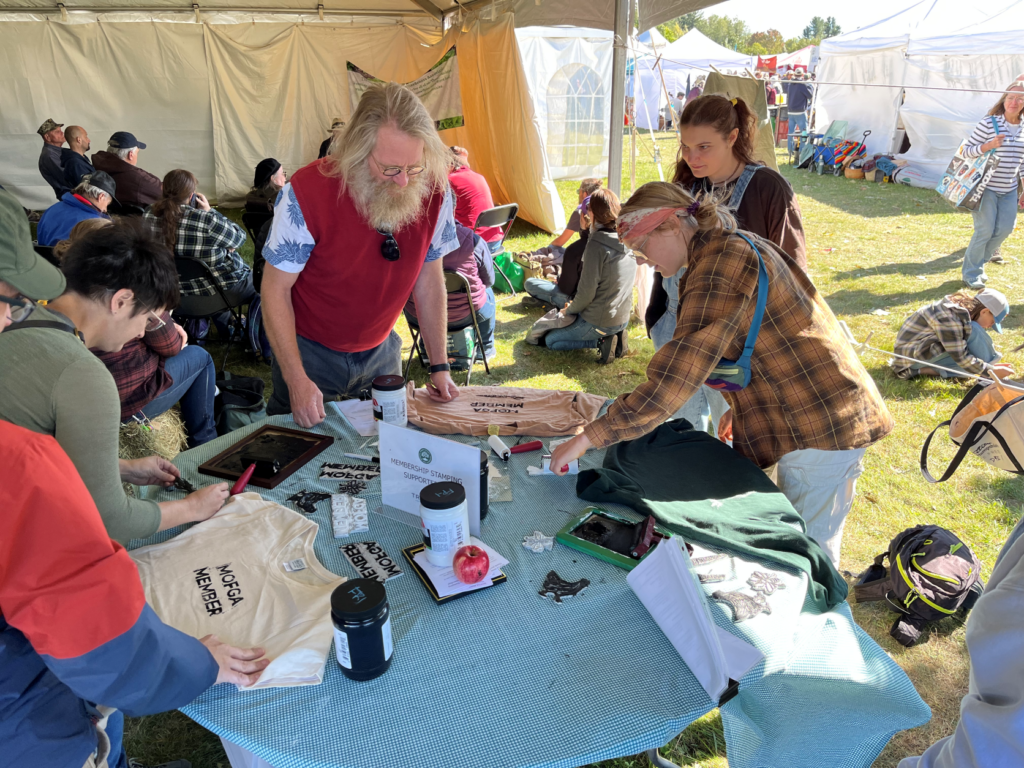 MOFGA members stand around a table using block prints on shirts.