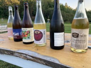 Various bottles of cider displayed on a wood table.