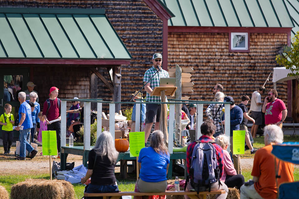 Ryan Parker stands on a podium in front of the common to deliver his keynote address.