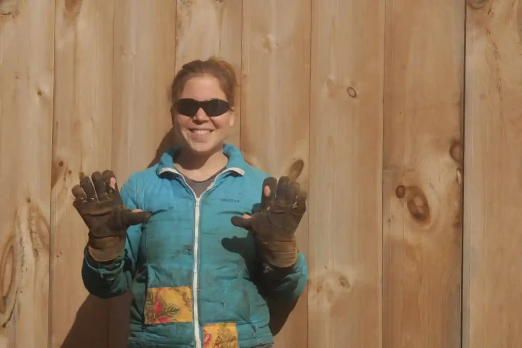 Katrina Amaral, of Tinderdoodle Farm, poses for the camera with working gloves and logging garb