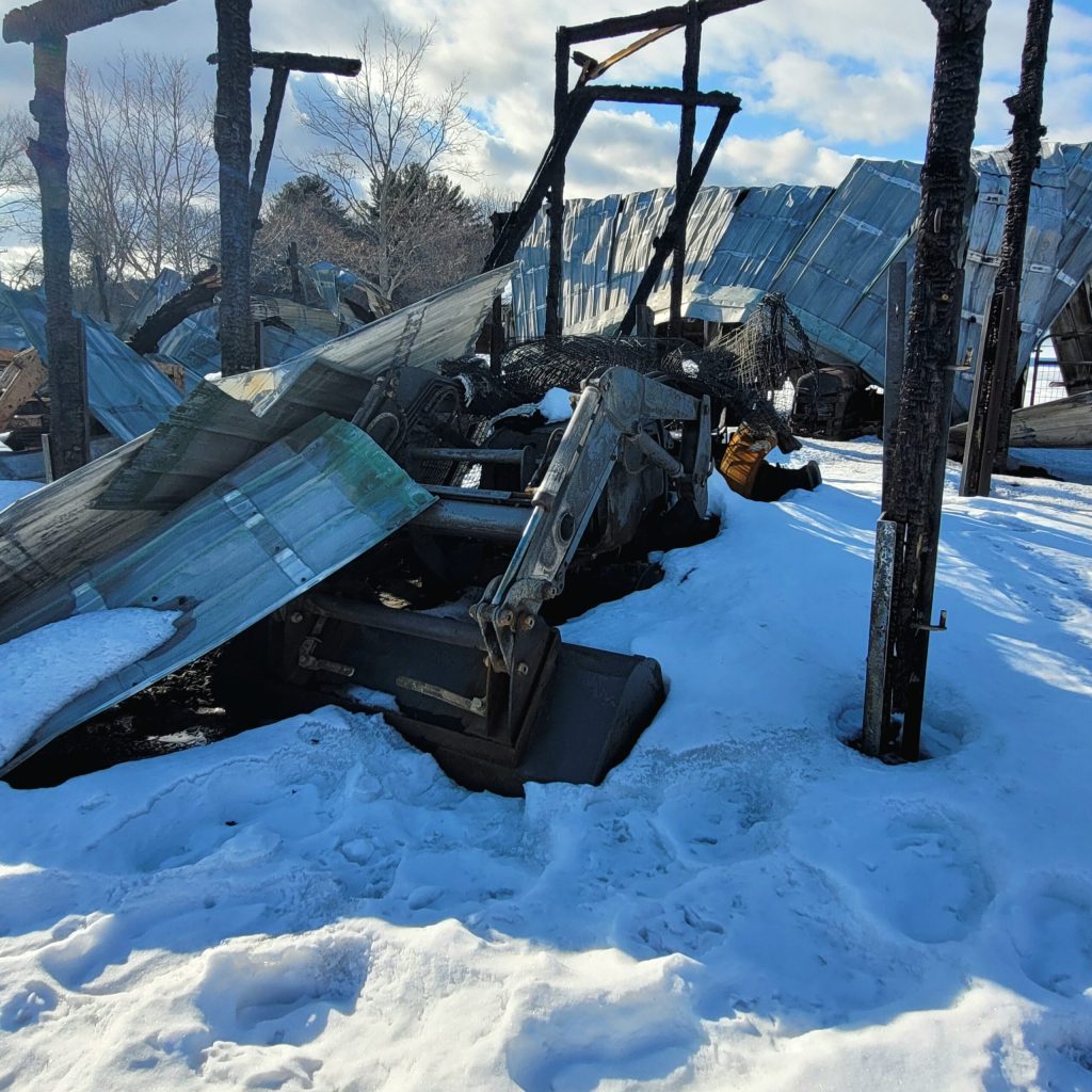 Debris from a barn fire on a snowy day.