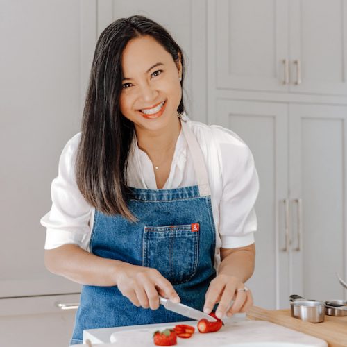 Sophie Eng cuts strawberries in a kitchen.