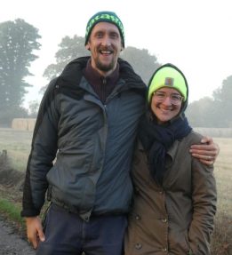 Two people smiling wearing winter gear.