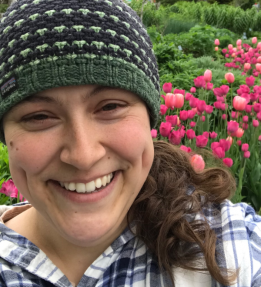 farmer smiling with flowers in backgrounf