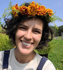 A farmer smiling wearing a flower crown of marigolds