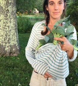 Farmer standing outside holding broccoli in their shirt